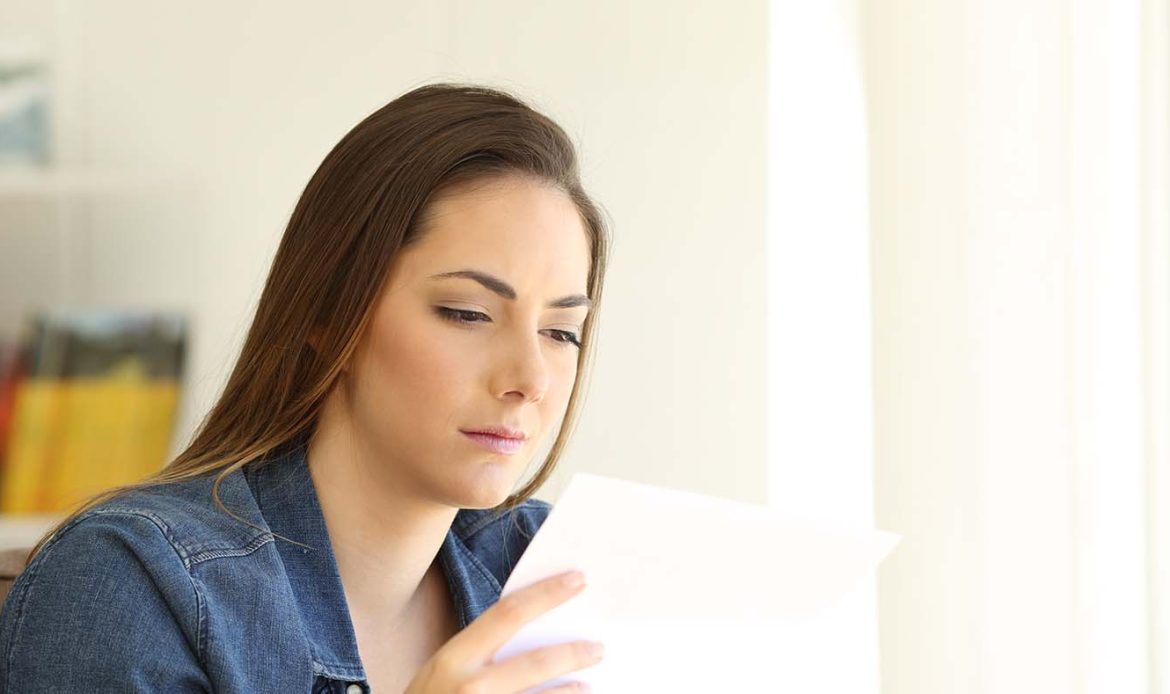 Woman reading a letter with a thoughtful expression, embodying the sentiment of receiving a letter to someone who is struggling.