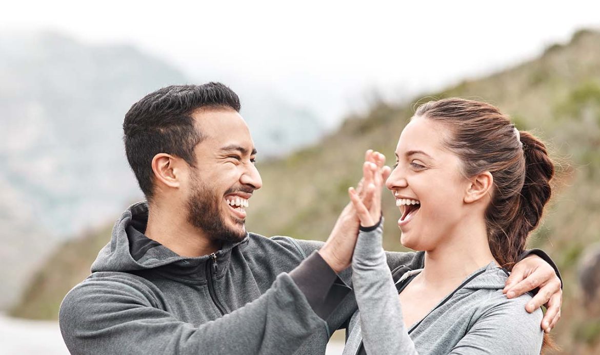 Two people enjoying a joyful moment outdoors, symbolizing a healthy work-home balance through shared activities and connection.