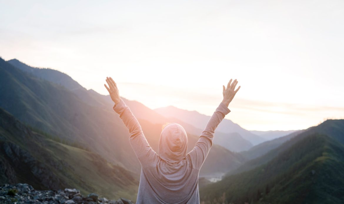 Successful adult woman hiker enjoy the view on cliff edge top of mountain