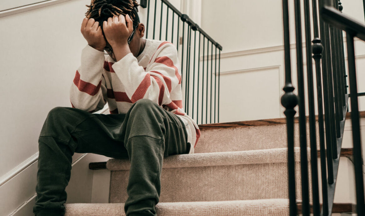 boy holding head in hands