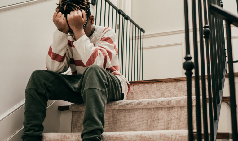 boy holding head in hands