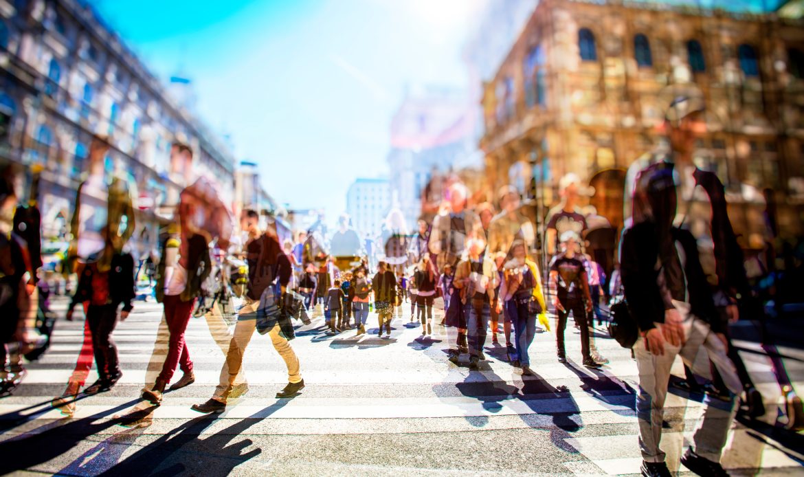 Crowd of anonymous people walking on busy city street