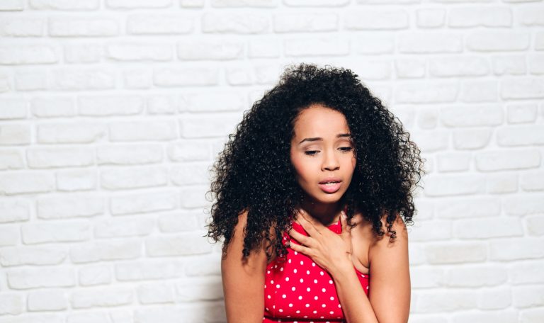 Portrait of nervous african american woman with panic attack. Black girl showing anxiety, sadness and frustration. Sad hispanic person against white wall