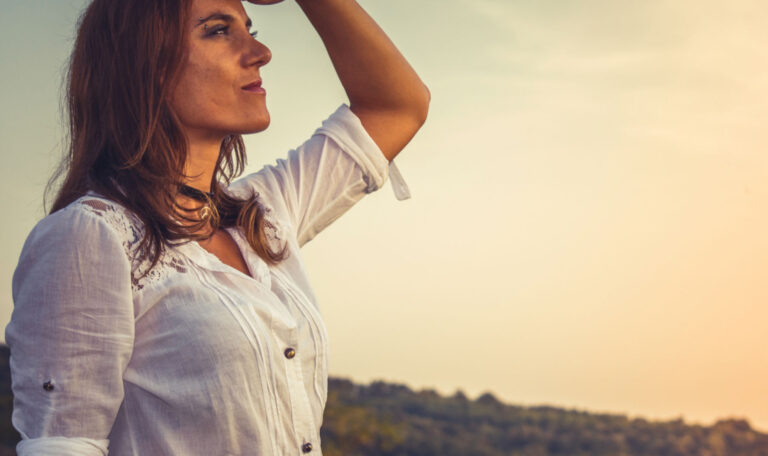 Woman looking thoughtfully into the distance, embodying the introspection and emotional preparedness often associated with anticipating grief.