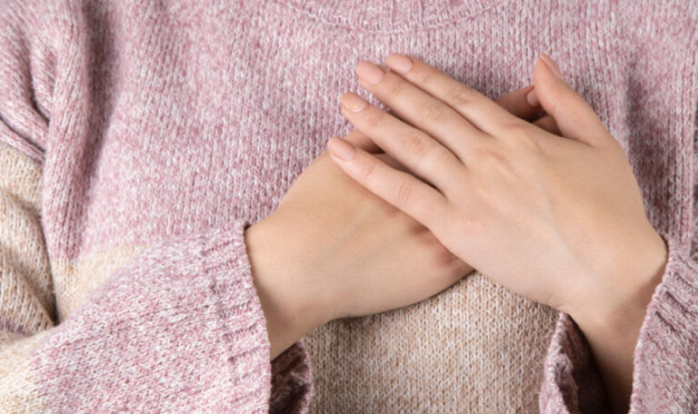 Person with hands over their heart, capturing a moment of gratitude in grief and the strength found in reflection.