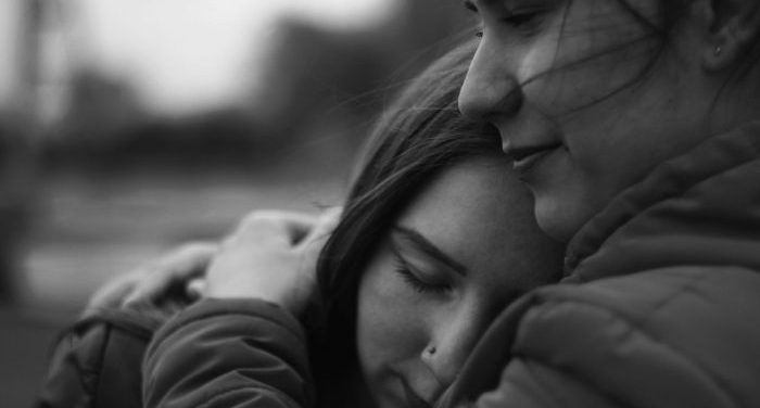 Two people embracing, providing grief support.