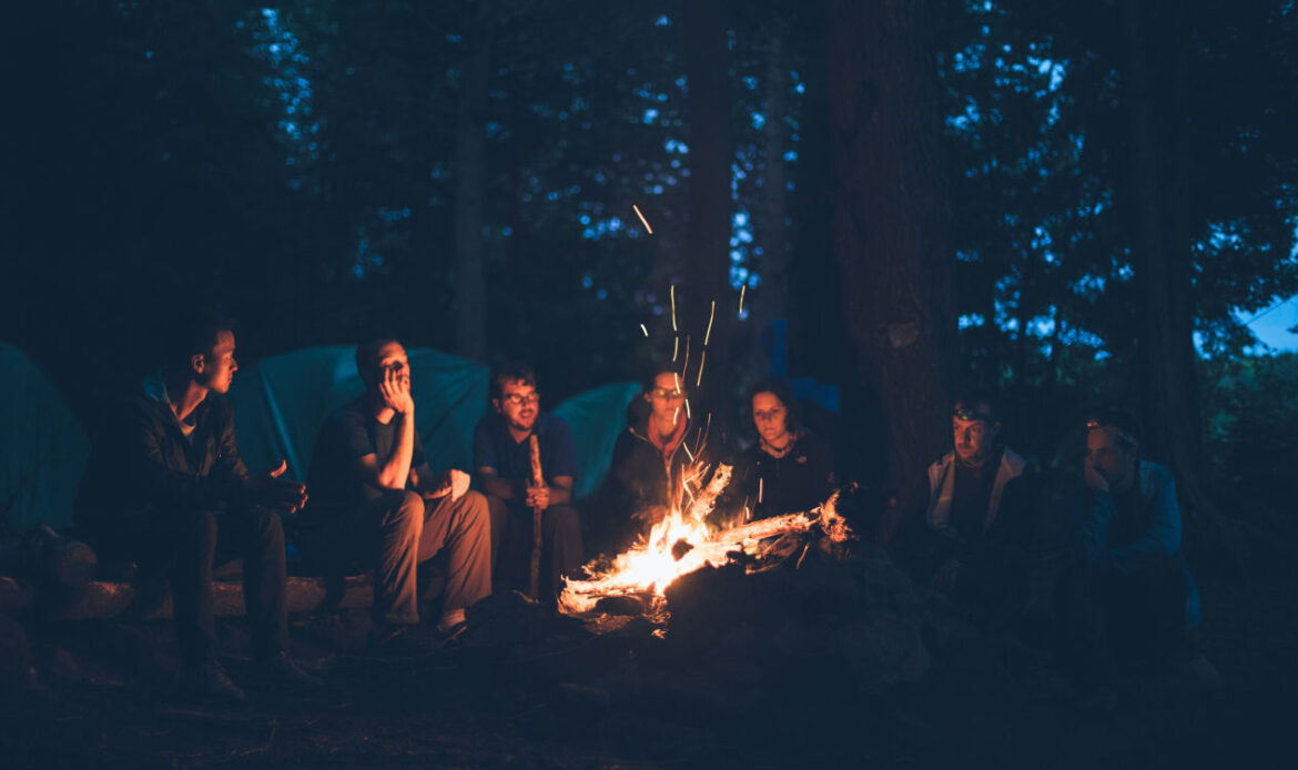 Sitting together around a fire, this group highlights the benefits of grief support groups.