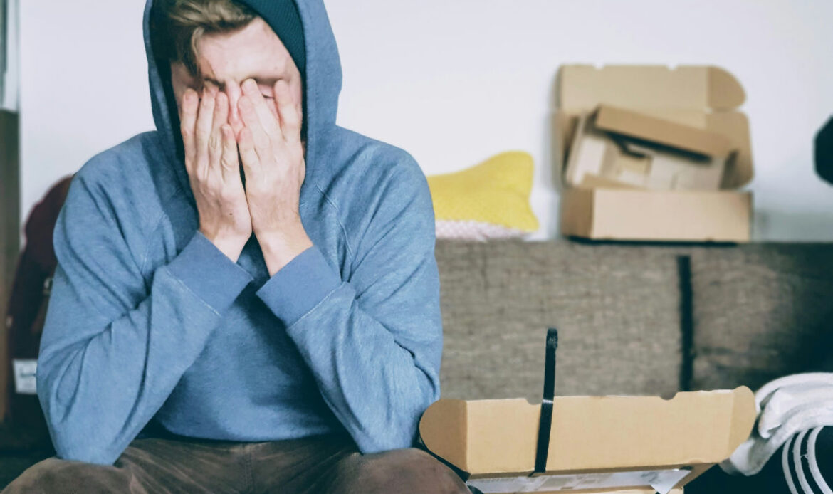 A person sitting with their face in their hands, reflecting feelings of being overwhelmed.