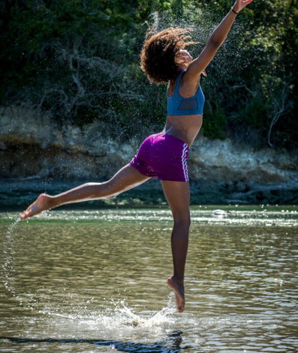 A person leaping joyfully in the water, reflecting the journey of finding meaning and purpose in life.