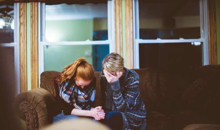 Two women sharing a moment of quiet support, showing that grief is love with nowhere to go.