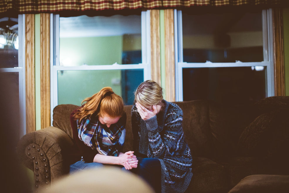 Two people comforting each other during a moment of shared grief, showing support during a difficult time.