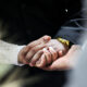 A woman holding her husband's hand, reflecting on love and loss after his passing.