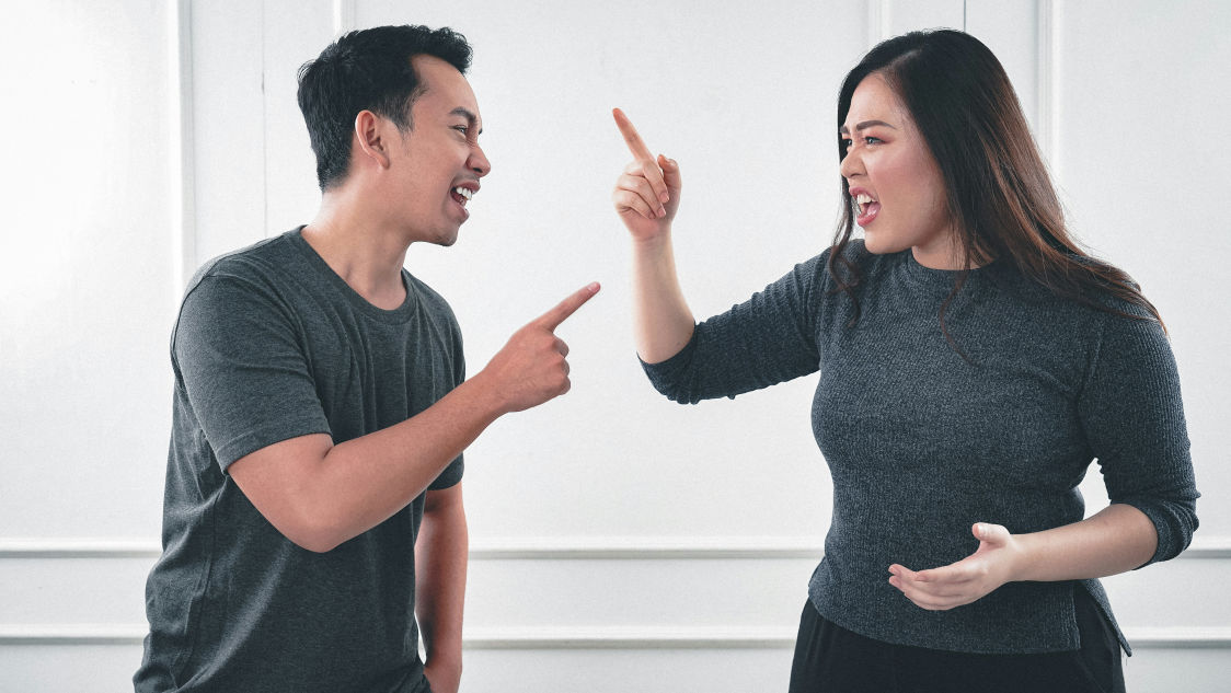 Two people arguing intensely, representing signs of trauma bonding in a conflicted relationship.