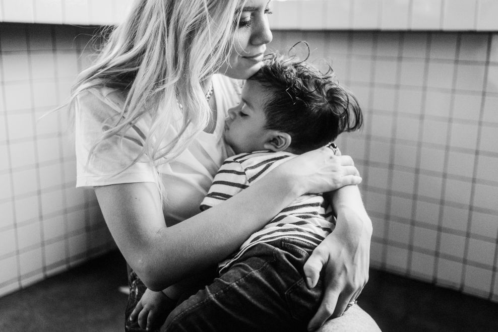 A mother holding her child close, capturing the emotional bond and grief following the loss of a mother.