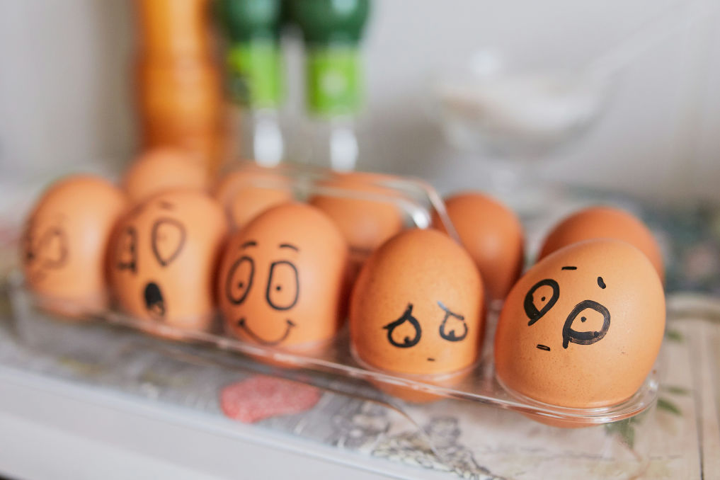 Eggs with various drawn faces illustrate how a person with bipolar thinks, shifting between different emotions.