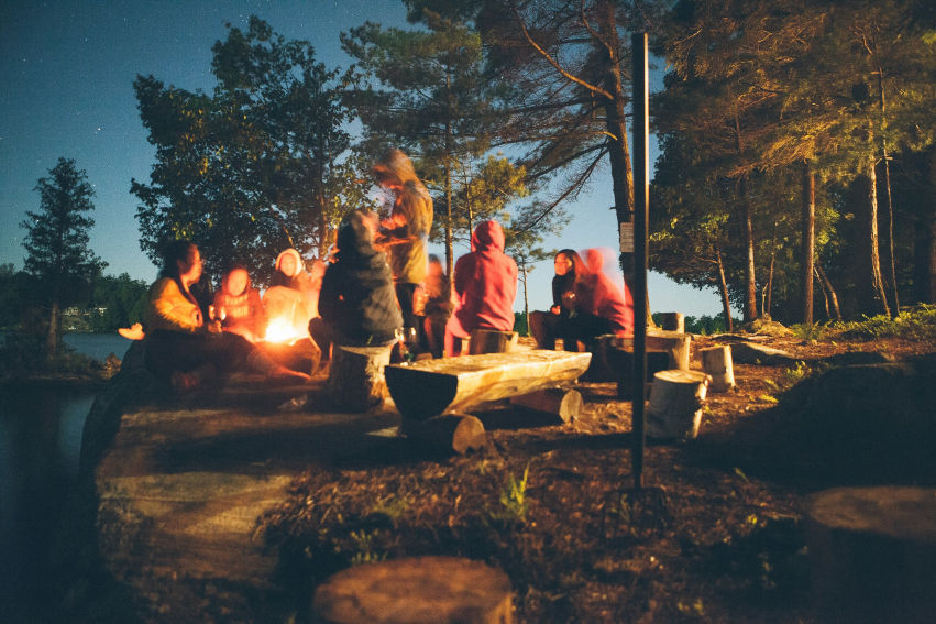 Group gathered around a campfire, symbolizing emotional healing and support through community.