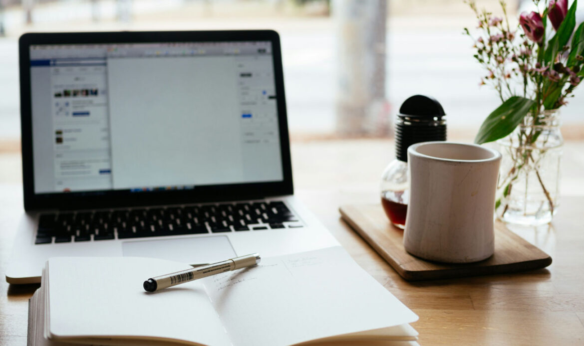 Open notebook and laptop on a desk, representing resources for a grief worksheet course.