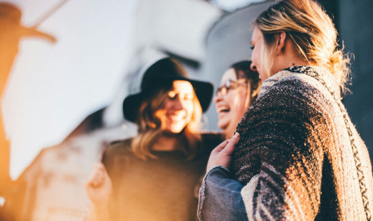 Group of people bonding and sharing smiles during a grief retreat.