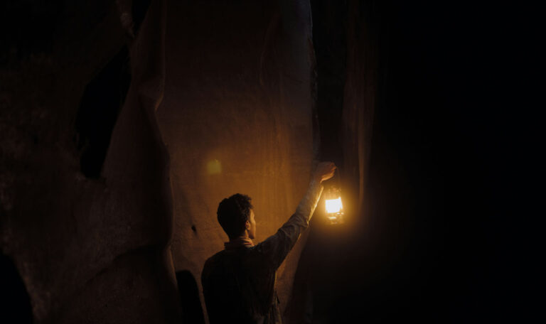 Person with lantern representing self-exploration.