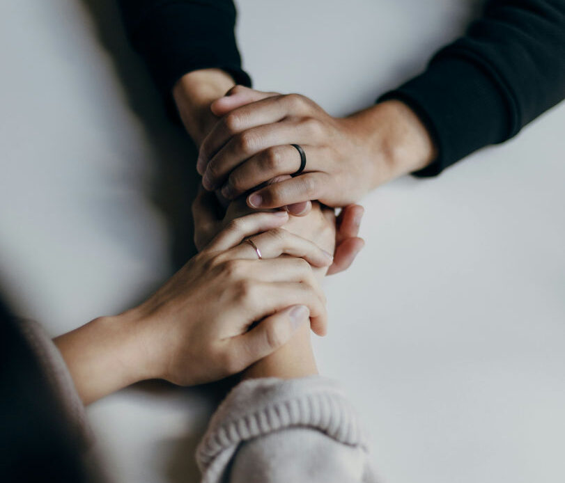 Hands held in support, reflecting being present for someone who lost a loved one.