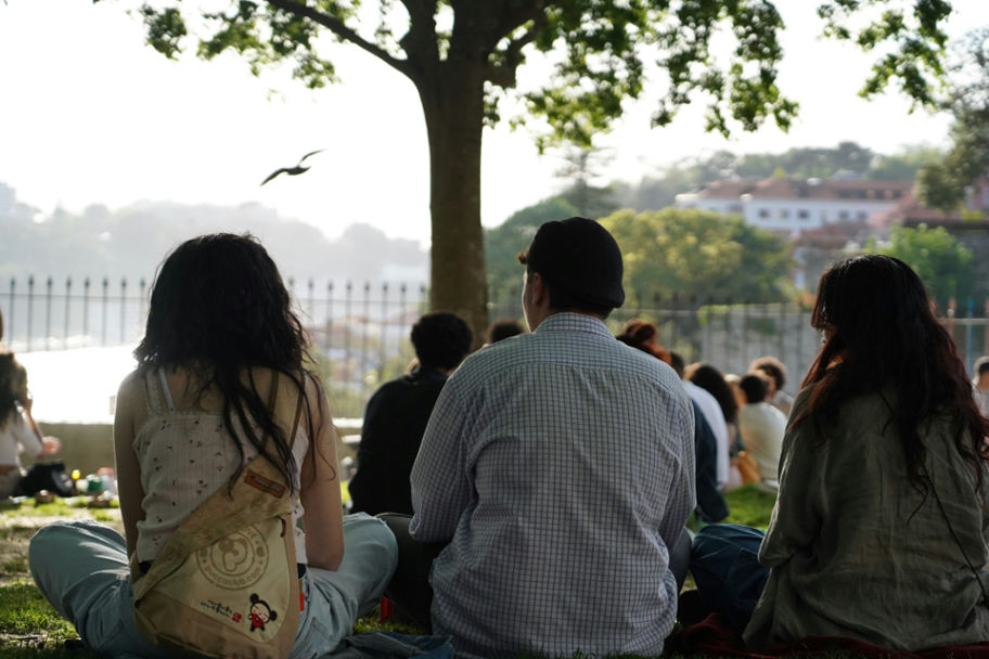 A group of people sitting closely under a tree, symbolizing the importance of building trust and fostering secure connections to heal anxious attachment.