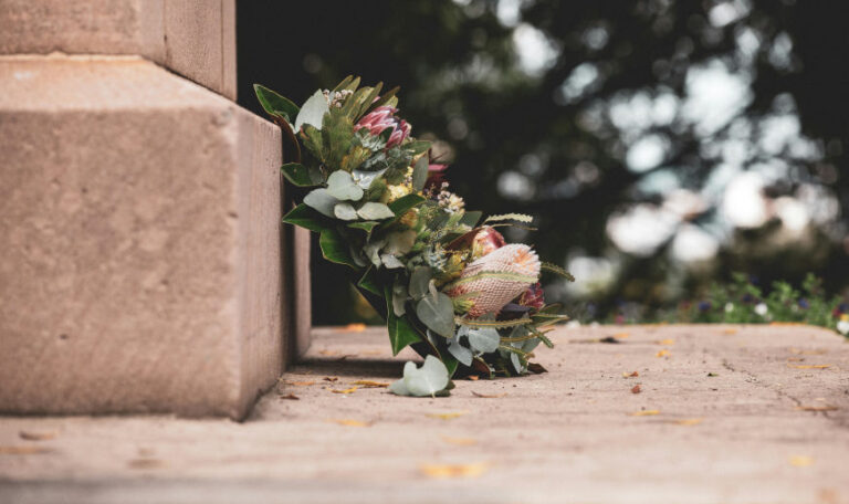 A floral wreath placed on stone steps, symbolizing remembrance and honoring a loved one on their one-year death anniversary.