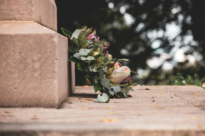 A floral wreath placed on stone steps, symbolizing remembrance and honoring a loved one on their one-year death anniversary.