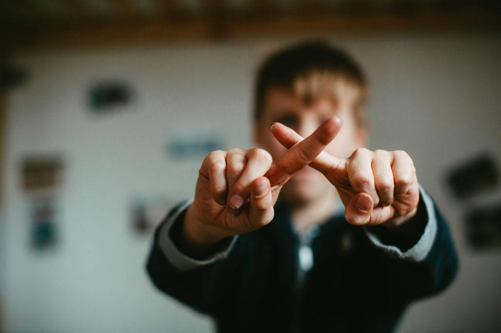 Child crossing fingers related to what to say to someone who lost a loved one.