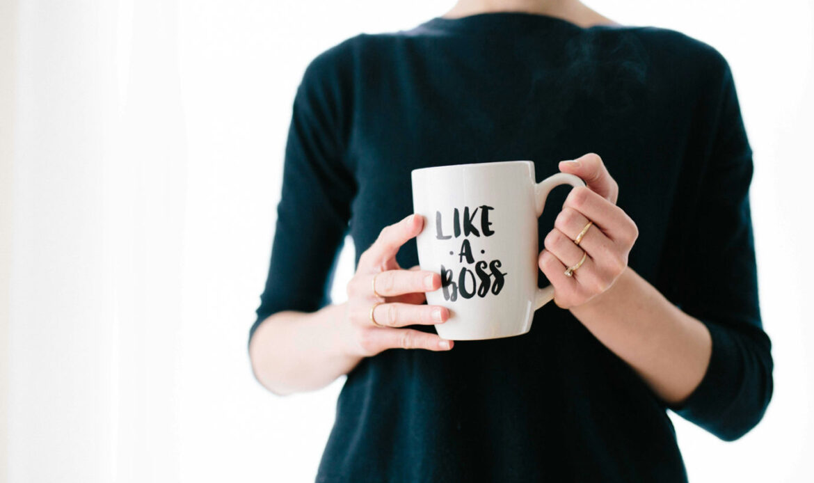 A woman holding a white coffee mug with the phrase 'Like a Boss' printed on it, symbolizing empowerment and confidence, representing affirmations for women.