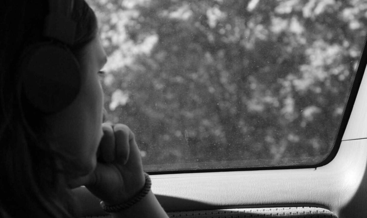 Grayscale portrait of woman inside a car.
