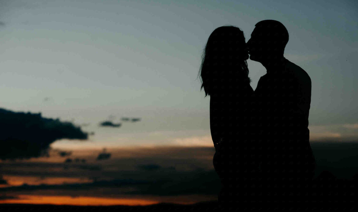Couple kissing at sunset
