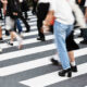 A crowd of people walking across a crosswalk, symbolizing the search for individuality and self-discovery amid the movement of everyday life.