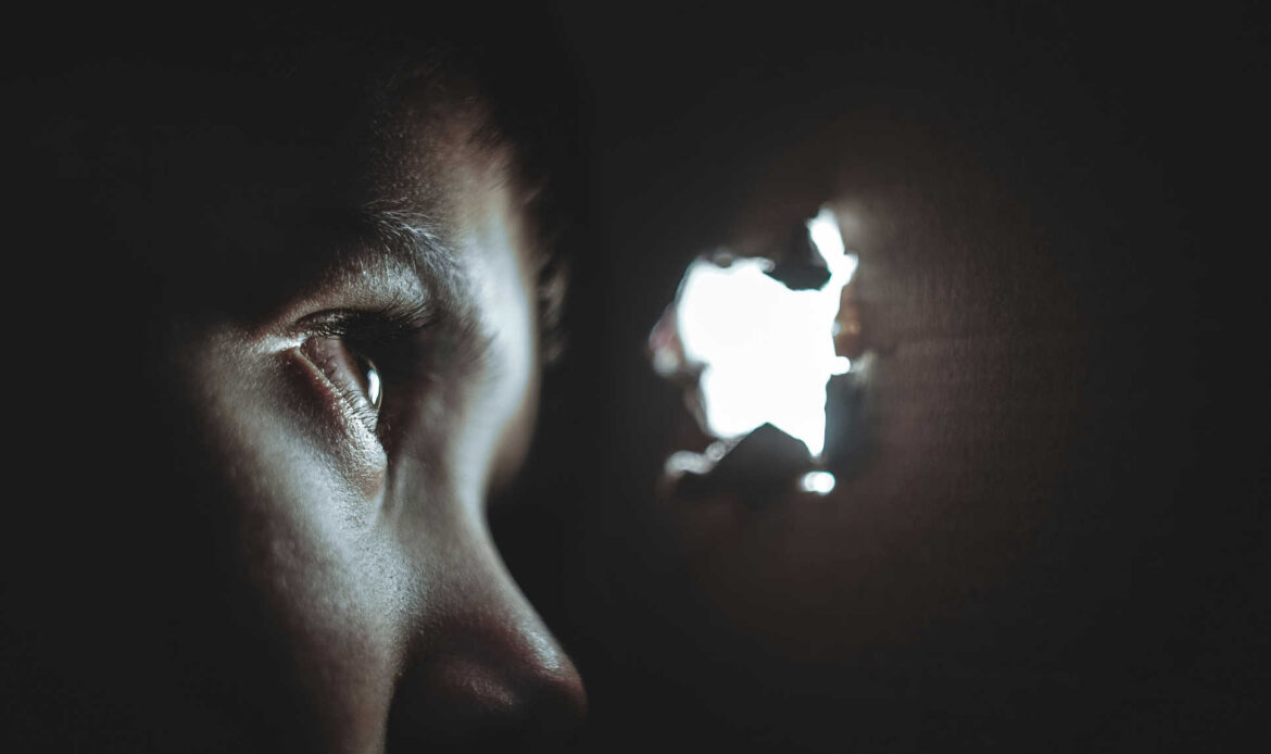 Eye peering through a hole