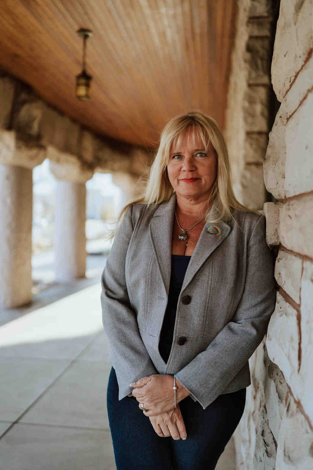 Dr. B standing confidently beside a stone wall, featured in the Strength in Vulnerability documentary film.