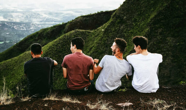 Four men sitting on a mountain trail