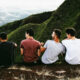 Four men sitting on a mountain trail