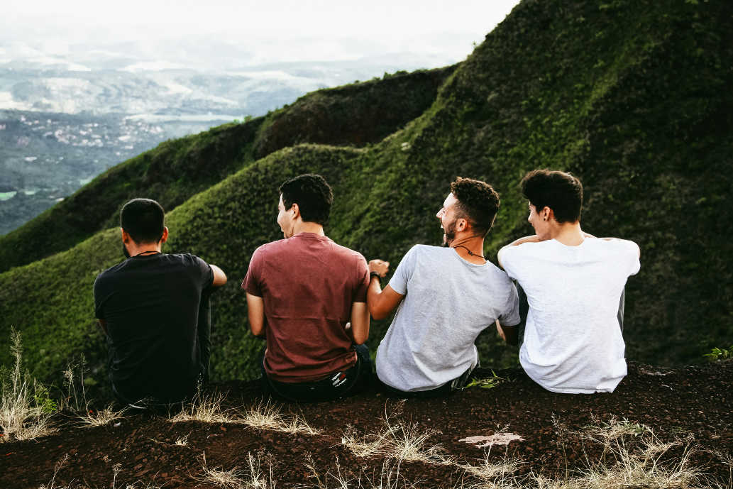Four men sitting on a mountain trail