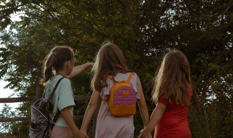 Young girls holding hands while walking together