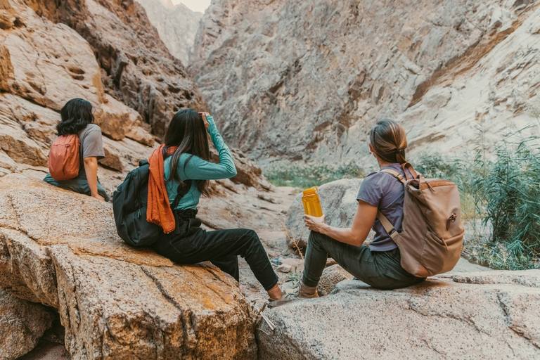 Group of people sitting on a rocky cliff