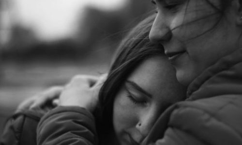 Two people embracing, providing grief support.