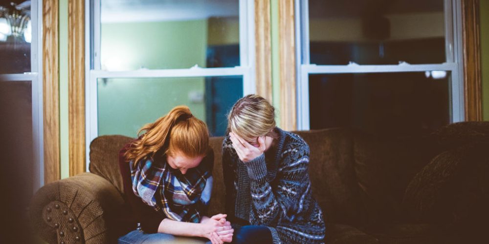 Two women sharing a moment of quiet support, showing that grief is love with nowhere to go.