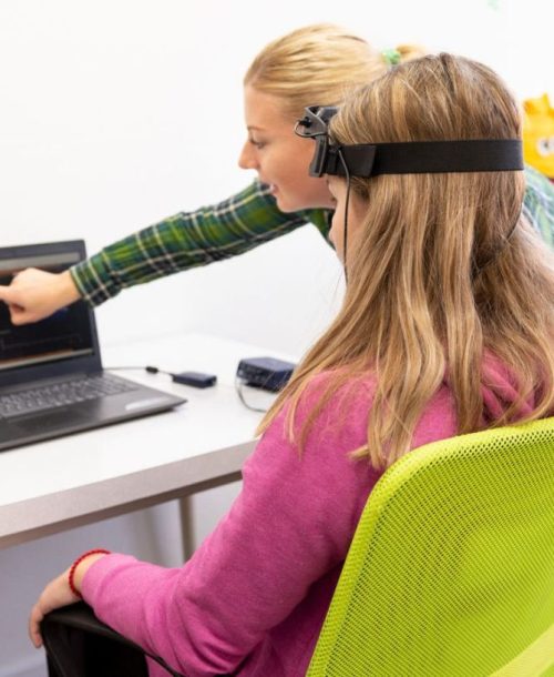 Therapist guiding a neurofeedback session with a young patient.